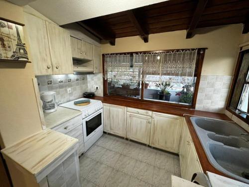 a small kitchen with a sink and a window at Moonbeam Townhouse Skiathos in Skiathos