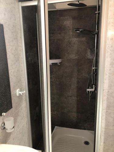 une douche avec une porte vitrée dans une salle de bain dans l'établissement Entre Paris et Disneyland Studio avec terrasse privée, à Gagny