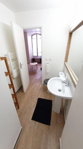 La salle de bains blanche est pourvue d'un lavabo et d'un miroir. dans l'établissement studio indépendant 2 personnes, à Auch