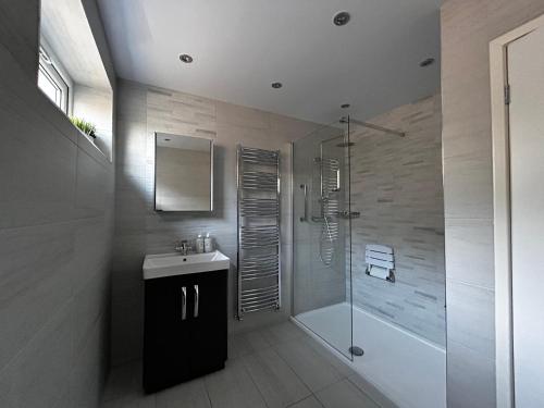 uma casa de banho com um chuveiro e um lavatório. em The Eves em Corbridge