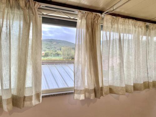 a window with curtains in a room with a view at Casa di Sara in Stiava