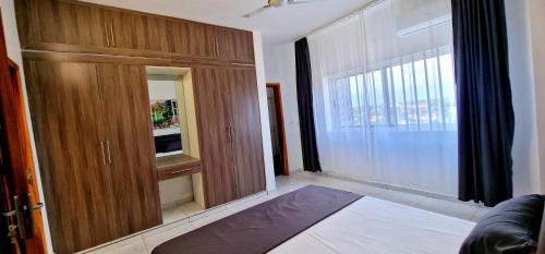 a room with a large wooden cabinet and a window at Évasion in Lomé
