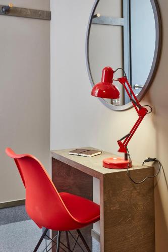 a red desk with a red lamp and a red chair at The Pier Rooms in Oban