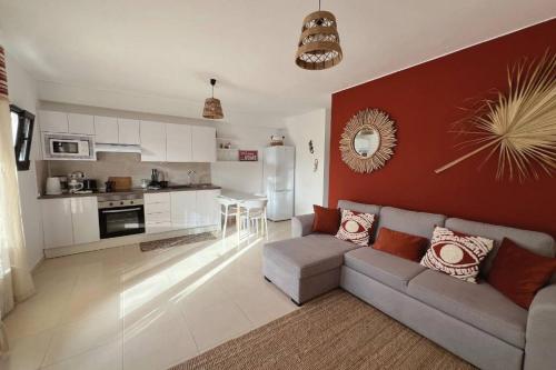 a living room with a couch and a kitchen at Casa Dorada Puerto del Carmen in Puerto del Carmen