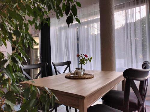 a dining room table with chairs and a table with flowers on it at KAMIENICA Pokoje & Restauracja in Opalenica
