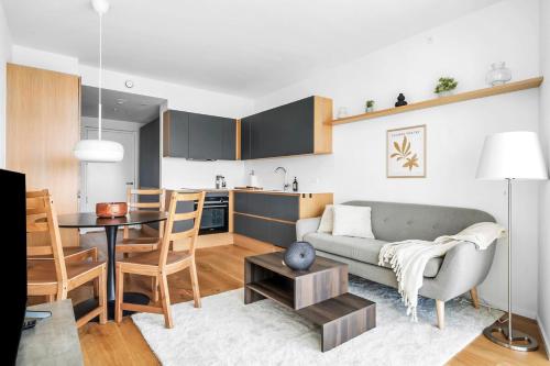 a living room and kitchen with a couch and a table at Above the clouds on 42nd floor in Aarhus