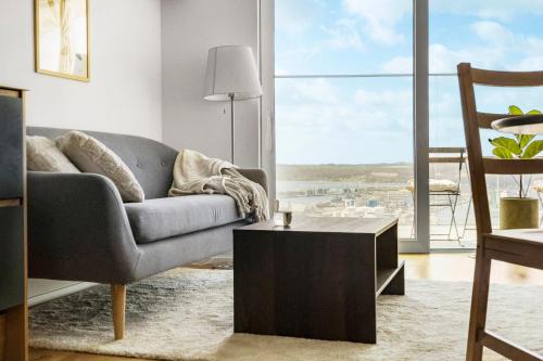 a living room with a couch and a table at Above the clouds on 42nd floor in Aarhus