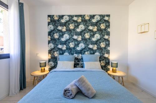 a bedroom with a blue bed with a floral headboard at Le Séquoia - Maison neuve climatisée in Saix