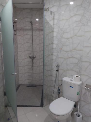a bathroom with a shower with a toilet and a glass door at Appartement de luxe Haut Founty in Agadir