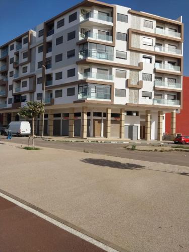 a large apartment building on a street with a parking lot at Appartement de luxe Haut Founty in Agadir