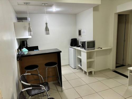- une cuisine avec un comptoir et des chaises dans la chambre dans l'établissement Apartamento Village Aldeia das Águas, à Barra do Piraí