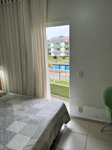 - une chambre avec un lit et une grande fenêtre dans l'établissement Apartamento Village Aldeia das Águas, à Barra do Piraí