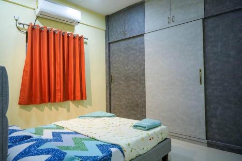 a bedroom with a bed and a red curtain at Casa Feliz @ Near US Embassy , Gachibowli in Hyderabad