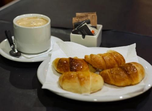 une assiette de beignets sur une table avec une tasse de café dans l'établissement Hotel Don Enrique, à El Soberbio