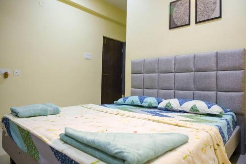 a bedroom with a bed with blue pillows on it at Casa Feliz @ Near US Embassy , Gachibowli in Hyderabad