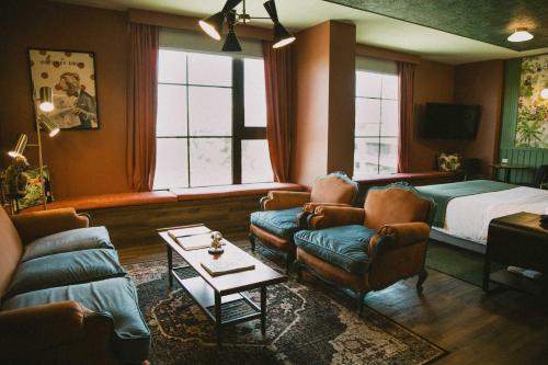 a living room with a bed and a couch and chairs at Hotel Eco Boutique Bidasoa in Santiago