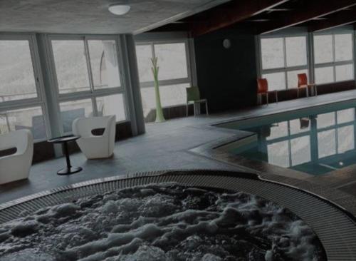 a room with a swimming pool with a pool at Duplex avec piscine et sauna in Jausiers