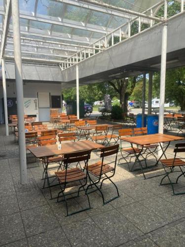 a group of tables and chairs under a building at POP UP dorms and camping in Munich