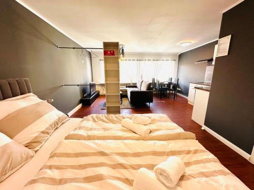 a bedroom with a large bed and a kitchen at Keli Apartments Zentrum Oldenburg in Oldenburg