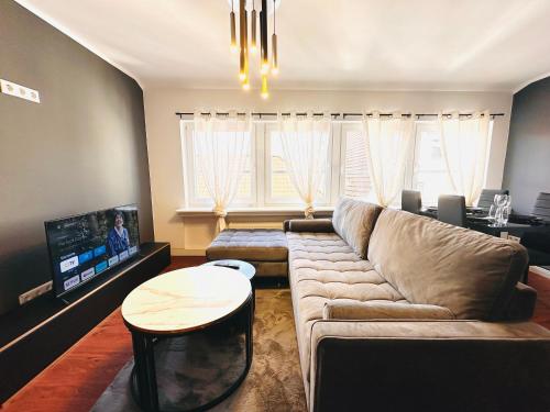 a living room with a couch and a tv at Keli Apartments Zentrum Oldenburg in Oldenburg