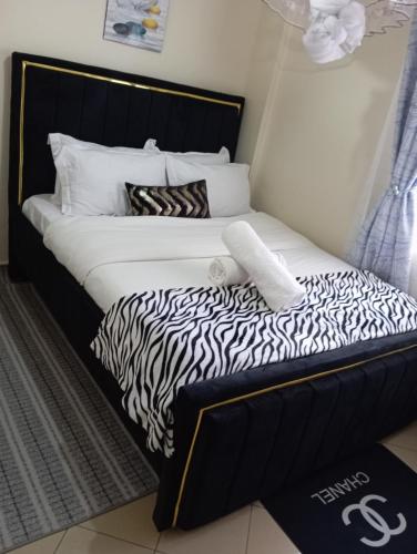 1 cama con sábanas de cebra en blanco y negro en Casa Gem, en Nairobi