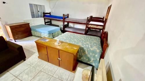 Pokój z 2 łóżkami, stołem i krzesłami w obiekcie Chácara Roteiro do Vinho com Wi-Fi w mieście São Roque