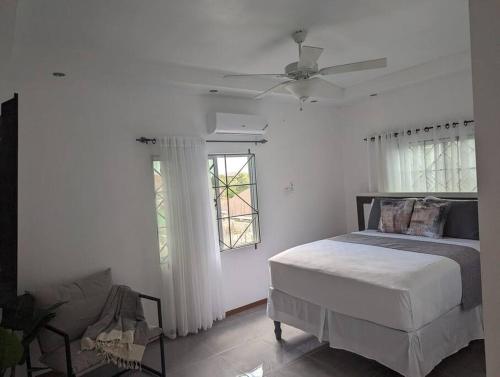 a bedroom with a bed and a ceiling fan at The Chateau Guesthouse- Old Harbour in Old Harbour