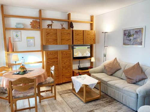 ein Wohnzimmer mit einer Couch und einem Tisch in der Unterkunft 3-Sterne Komfortferienwohnung  Köhnke 6 - [#122261] in Goslar