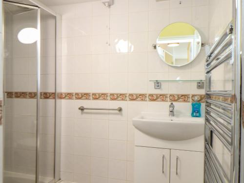 a bathroom with a shower and a sink and a mirror at Flat 1 Niles Place in Padstow
