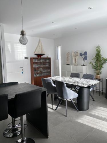 ein Esszimmer mit einem Tisch und Stühlen in der Unterkunft new architect villa with large terrace and patio 800 m from the sea in Vaux-sur-Mer