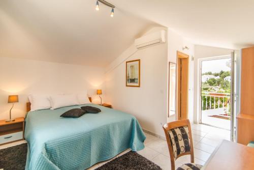 a bedroom with a bed and a table and a window at Luxury Beachfront Villa Casa Mare with private heated pool and gym right at the beach in Mirca - Brac in Supetar
