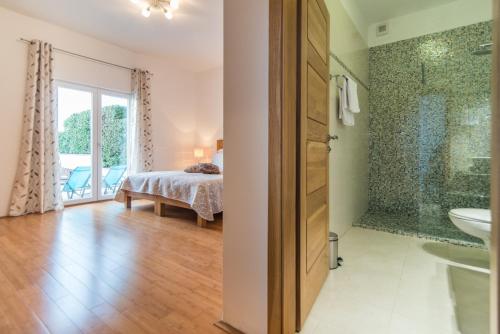 a bedroom with a bed and a bathroom at Luxury Beachfront Villa Casa Mare with private heated pool and gym right at the beach in Mirca - Brac in Supetar