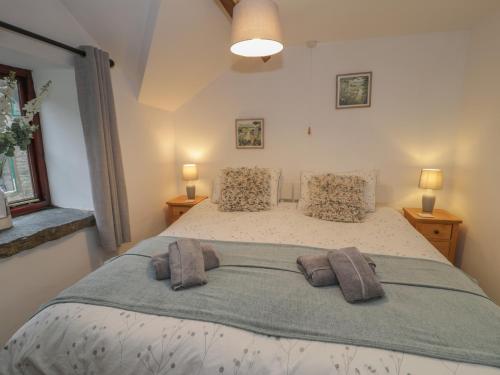 a bedroom with a large bed with two pillows at Graig Las The Stables in Oswestry