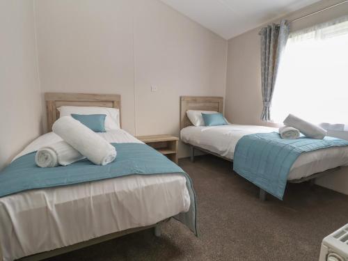 1 Schlafzimmer mit 2 Betten und einem Fenster in der Unterkunft Lodge 9 in St Asaph