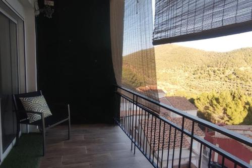 uma varanda com uma cadeira e uma grande janela em Apartamento en la montaña, Serra em Serra