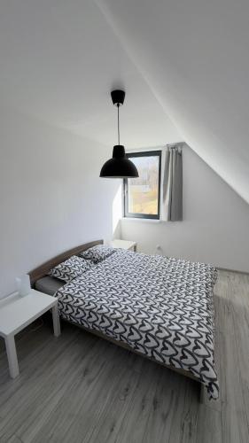 a bedroom with a black and white bed and a window at Lubiatówki in Lubiatowo