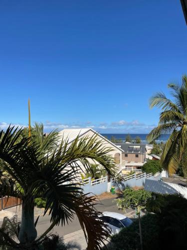 a view of a building with palm trees in the foreground at Appartement T2 La Saline Les Bains in Saint-Paul