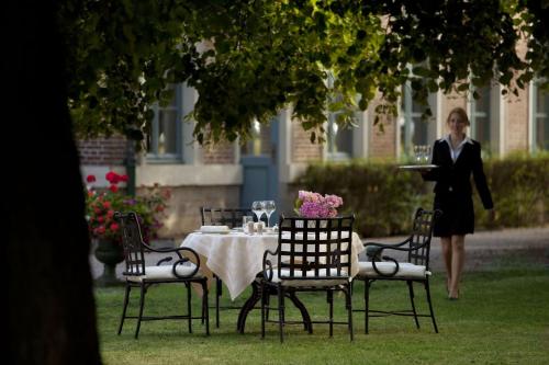 a woman standing in front of a table with a plate of food at La Chartreuse Du Val Saint Esprit in Gosnay