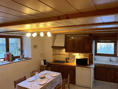 une cuisine avec une table et un chiffon de table blanc dans l'établissement Appartement de Charme, à La Plagne Tarentaise