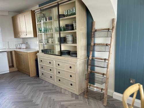 a kitchen with a white cabinet with dishes on it at Gorey retreat main house in Gorey