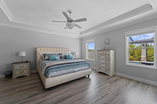 um quarto branco com uma cama e uma ventoinha de tecto em High-End Gulf Getaway with Pool & Hot Tub em Port Charlotte