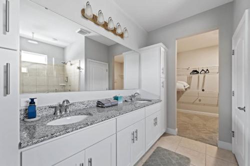 uma casa de banho com um lavatório e um espelho grande em High-End Gulf Getaway with Pool & Hot Tub em Port Charlotte