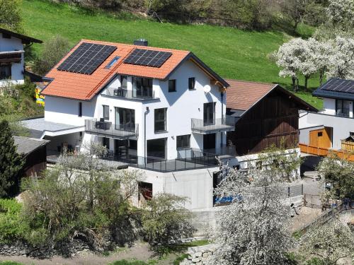 una casa con paneles solares en el techo en Apart Alpenzeit, en Arzl im Pitztal