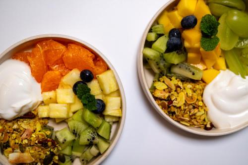 two bowls of food with fruits and vegetables and yogurt at Odit in Bruges
