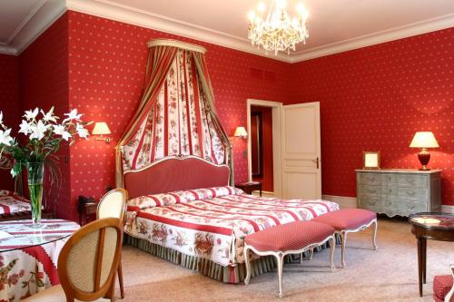 a bedroom with red walls and a bed and chairs at La Chartreuse Du Val Saint Esprit in Gosnay