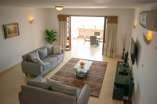 La Mera Beachfront Apartment في مومباسا: غرفة معيشة مع أريكة وطاولة