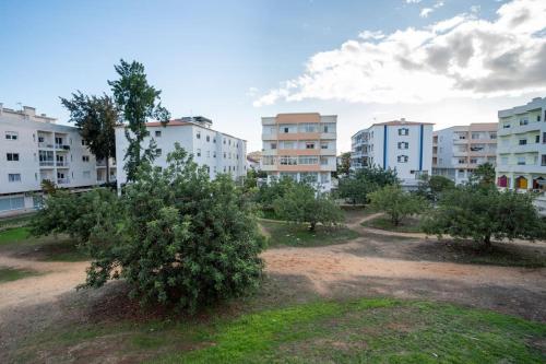 a group of apartment buildings with trees in a field at Blife Allya private rooms in Faro