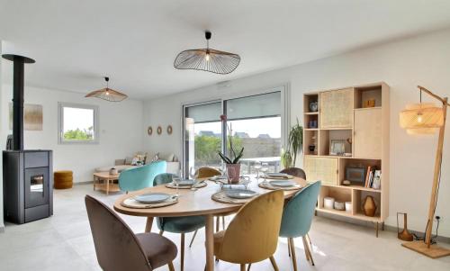 une salle à manger et un salon avec une table et des chaises dans l'établissement Maison bord de mer avec Jacuzzi, à Penmarcʼh