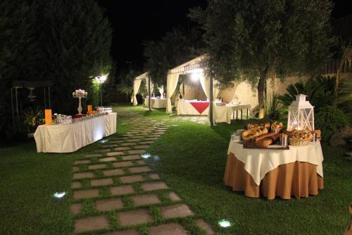 a group of tables with food on them in the grass at Hotel Ristorante Paradise in Santa Maria di Licodia