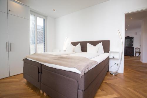 una camera da letto con un grande letto con lenzuola bianche di NEU - MoselAUSZEIT Traben a Traben-Trarbach